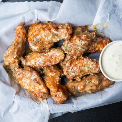 Garlic Parmesan wings served with creamy sauce.