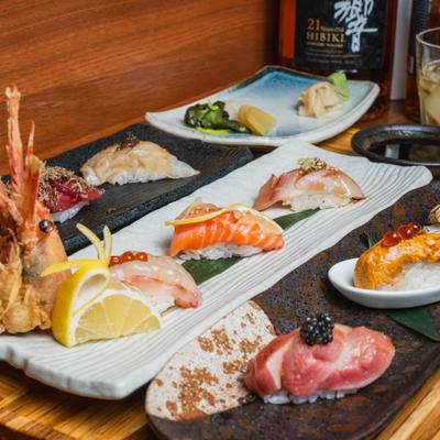Variety of nigiri sushi served on plates in a restaurant setting.