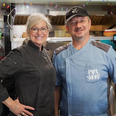 The chef and the owner posing together in the kitchen.