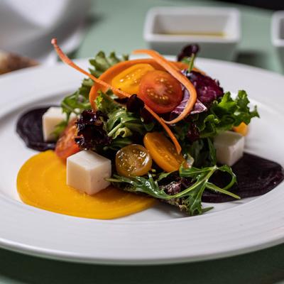 Beet salad with cherry tomatoes, arugula, greens and cheese.