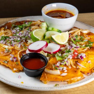 Quesa-Birria served with lime wedges, radish slices, dipping sauce and consomme.