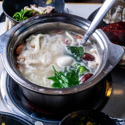 Hot pot meal featuring shrimp, vegetables, red dates and greens.
