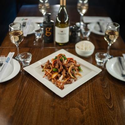 Crispy shredded beef served rice, alongside drinks and condiments.