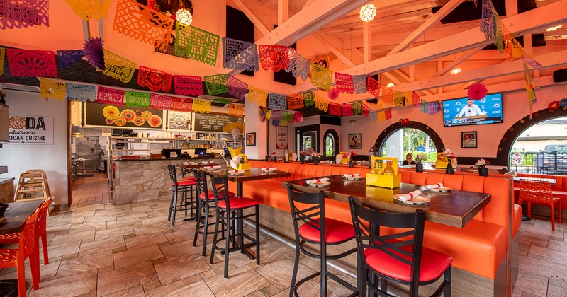 Lively Mexican-style interior, spacious dining area decorated with hanging paper ornaments