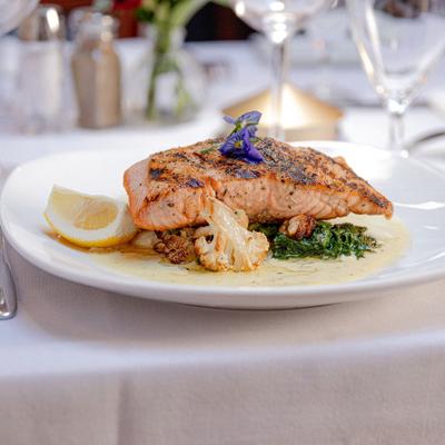 Grilled salmon fillet served with broccoli rabe and cauliflower.