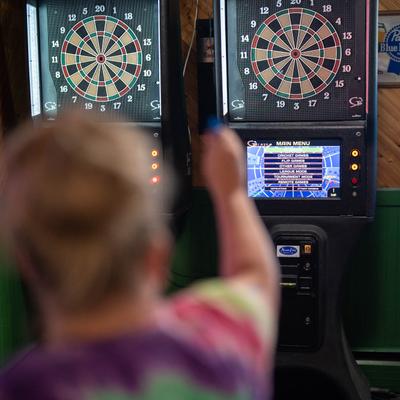 A guest playing darts inside.
