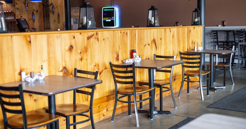 Interior, wooden tables and chairs, a wooden panel wall, and decorative elements
