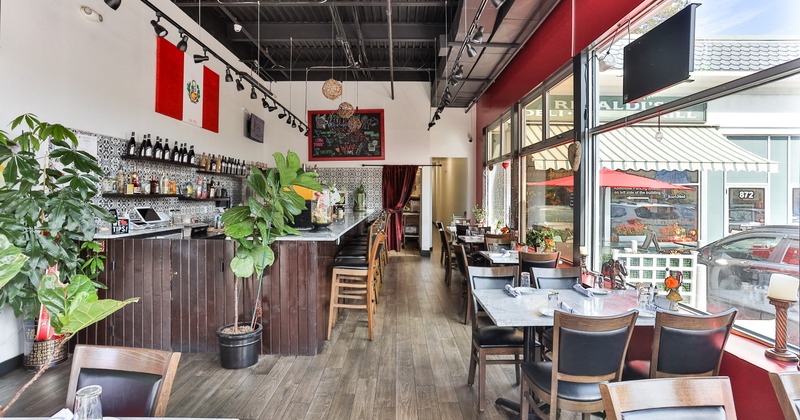 Interior, bar and dining area with set tables lined up by windows