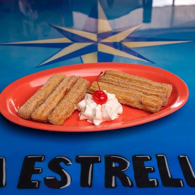 Churros, with whipped cream and cherry.
