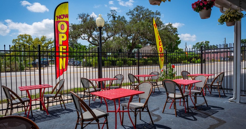 Exterior, partially covered seating area, tables for two, high railing , street view