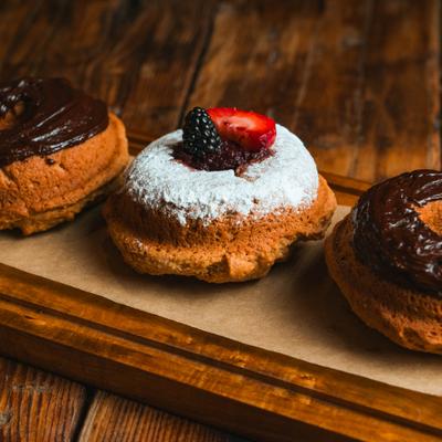 Assorted donuts displayed on a wooden board.
