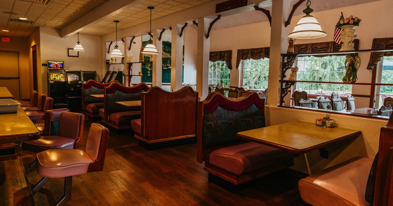 Interior seating area with wooden booths, pendant lights and large windows