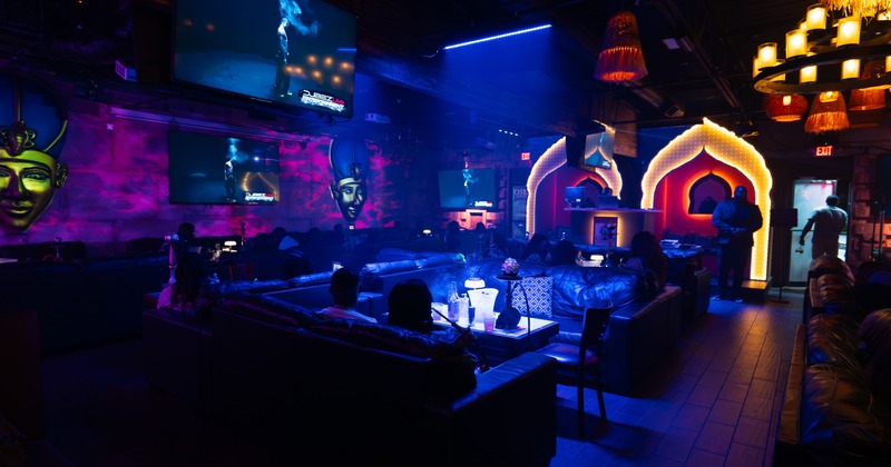 Interior, dimmed colored lights, imitation of arpian architecture, wide view of the seating area