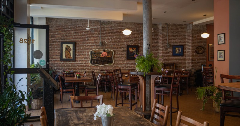 Interior, dining area, wooden tables and chairs, high and regular seating, brick walls