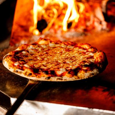 Margherita pizza being baked in a stone oven.