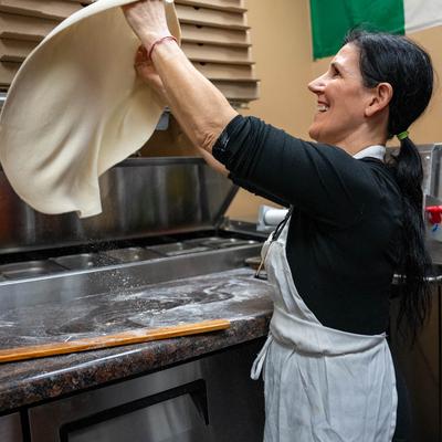 Kitchen shots, a pizza maker in action.