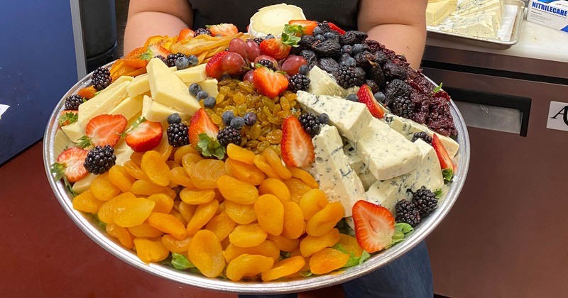 Large plate with cheese, dried fruit and fresh berries