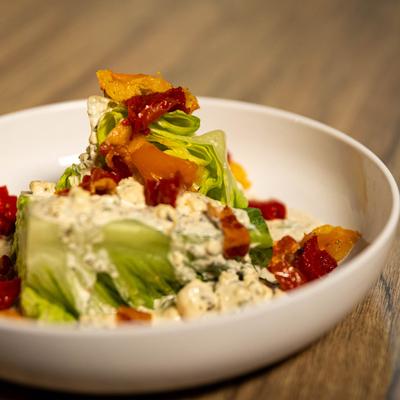 Romaine Wedge Salad, with bacon, shallots, tomato, blue cheese, and buttermilk dressing.
