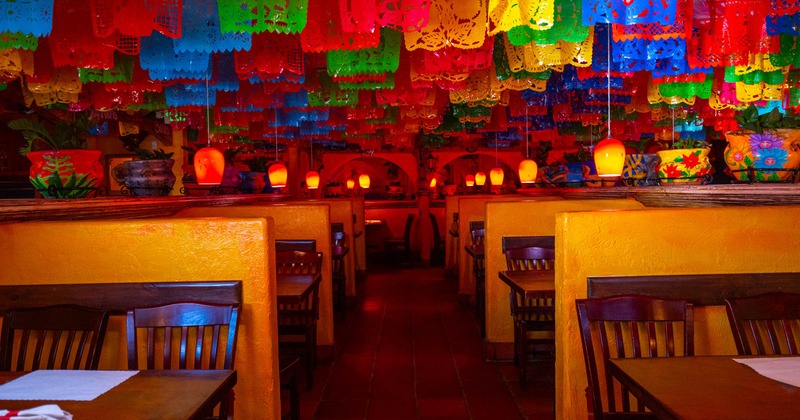 Interior, dining area, wooden tables and chairs divided by a low walls