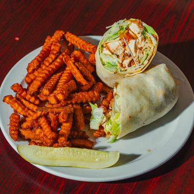 Buffalo Chicken Wrap served with crinkle cut fries and a pickle sprear.