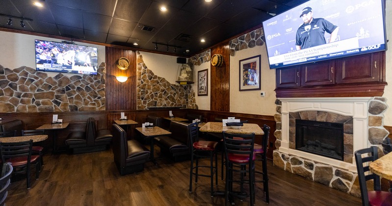 Interior. tables and seating, fireplace, wall TV screens