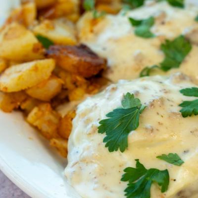 Biscuits and gravy with a side of home fries, close-up.