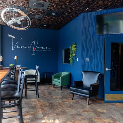 Wine bar interior wit blue walls, stools, and comfortable armchairs.