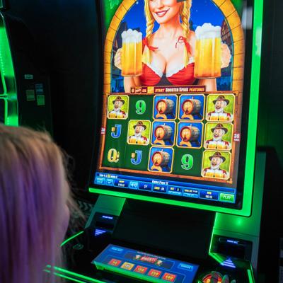 Player using a slot machine with a bright screen and game symbols.