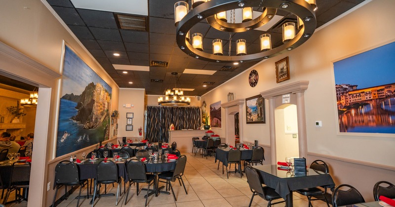 Restaurant interior with tables, chairs, chandeliers and wall paintings