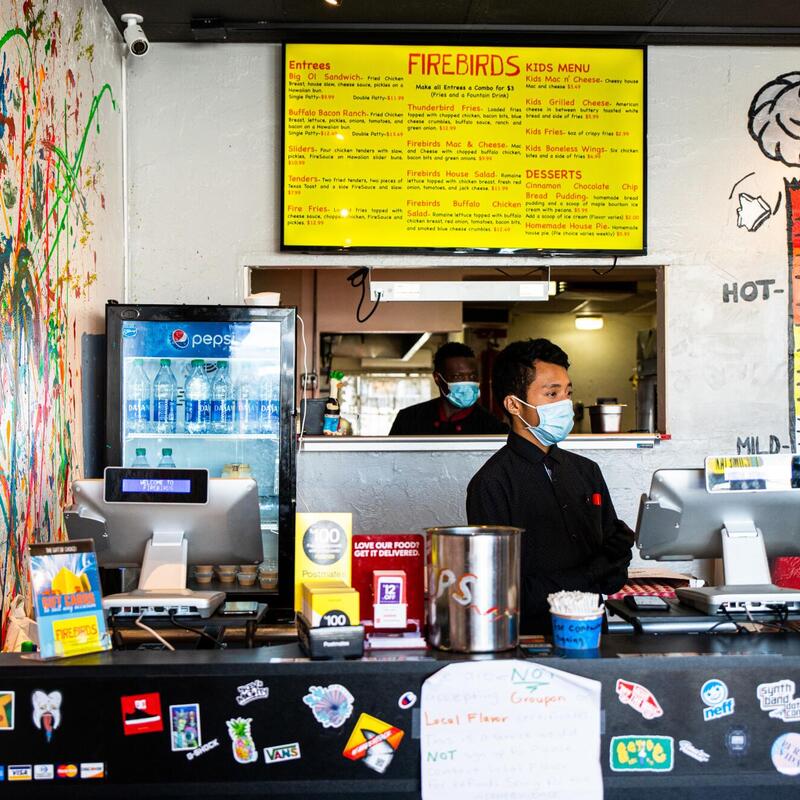 Staff member with a sanitary mask behind the counter