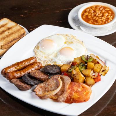Irish Breakfast with fried eggs, sausages, bacon, black pudding and fried potatoes.