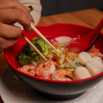 A person eating Seafood Nabe Yaki Udon.