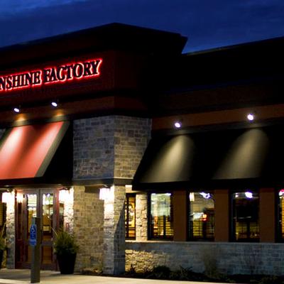 Sunshine Factory exterior at night with a red illuminated sign.