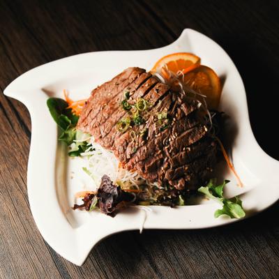 Cooked beef served over a bed of shredded white daikon radish and mixed greens.