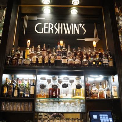 Gershwin's mirror logo with bottles on shelves.