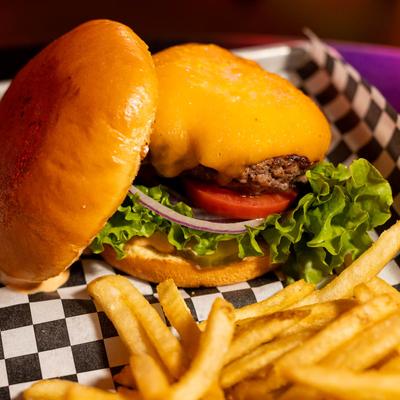 Cheeseburger served with fries, closeup.