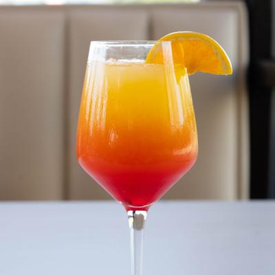 Sunrise Bliss cocktail, served in a stemmed glass with citrus garnish.