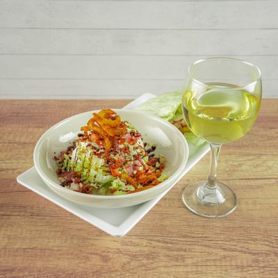 Wedge salad paired with a glass of white wine.