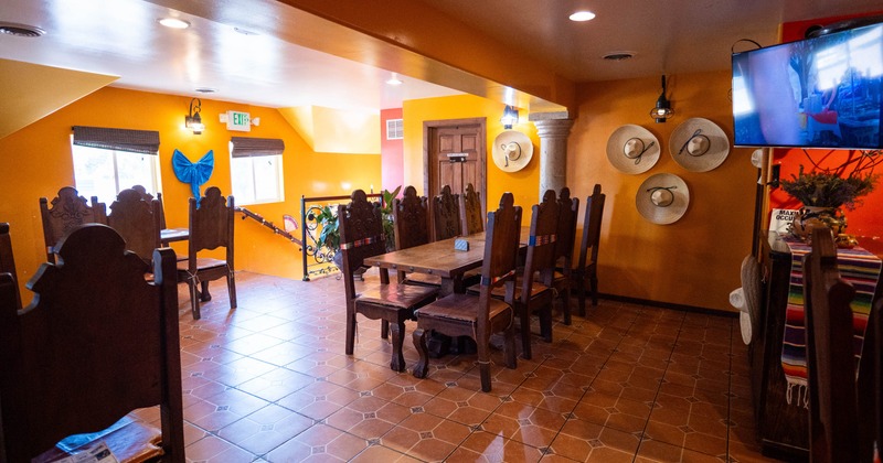 Interior featuring vibrant orange walls, wooden furniture and wall-mounted sombreros