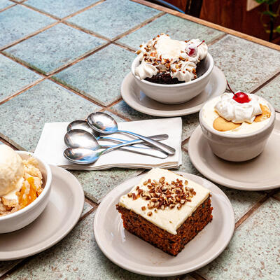 Assorted desserts presented on a square tiled tabletop.