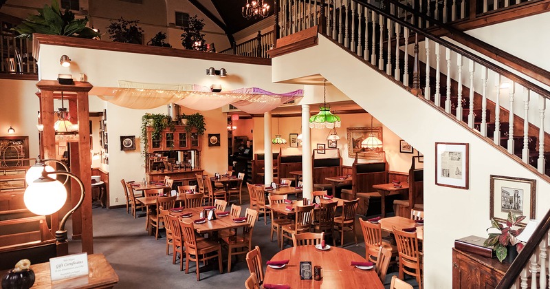 Restaurant interior, dining area with set tables, stairs for the second floor