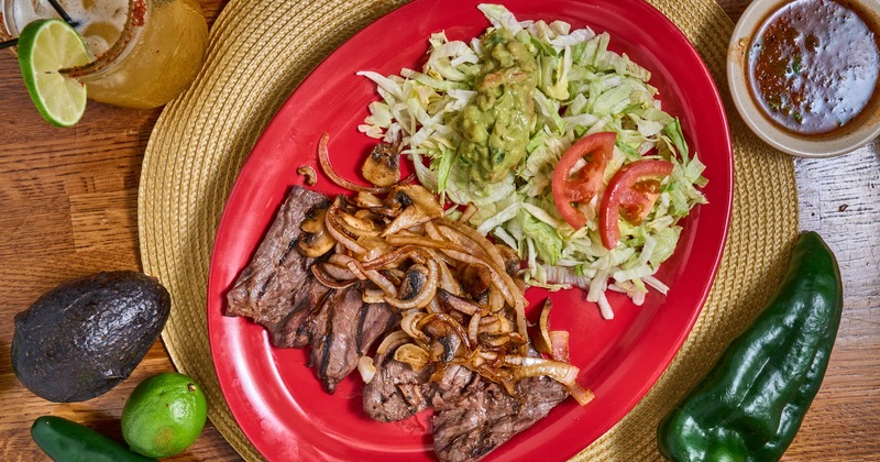 Grilled steak, with sauteed onions, mushrooms, salad, and guacamole