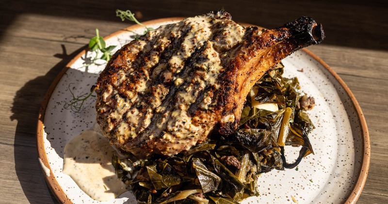 Grilled pork chop with cheese grits and collard greens