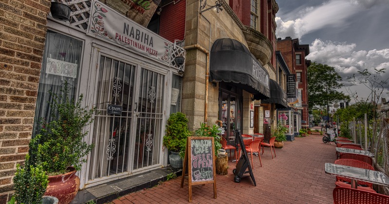 Exterior, side view to restaurant and sidewalk, tables and chairs, info A- boards