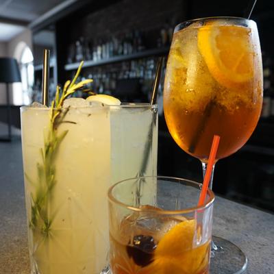 Assorted cocktails with citrus garnishes on bar counter.