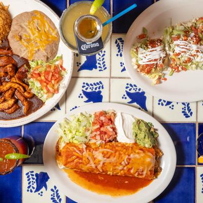 Multiple food plates accompanied with two cocktails, top view.