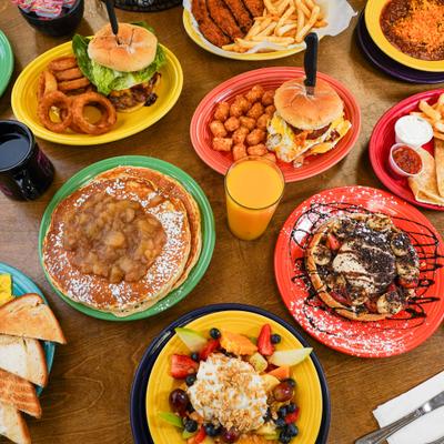 Various breakfast and lunch items served on the table with drinks.
