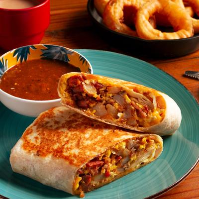 A breakfast burrito and a bowl of salsa, accompanied with onion rings and a cup of coffee.