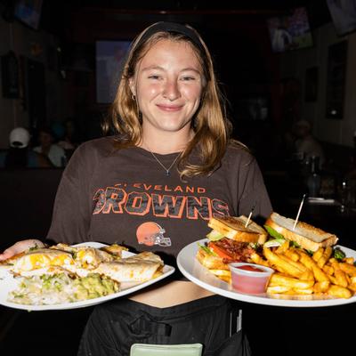 A staff member smiling and holding dishes.