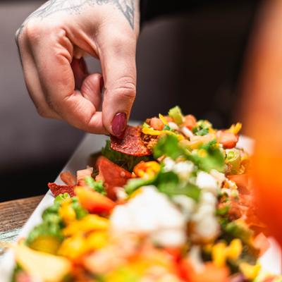 Hand taking a bite from taco salad.